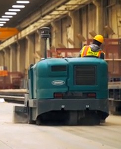 Varredora de pavimentos da Tennant Company com filtro HEPA a limpar pó de sílica no pavimento da fábrica